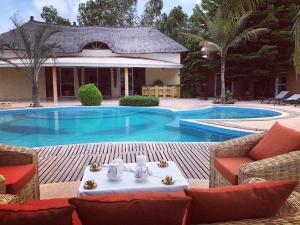a swimming pool with a table and chairs in front of a house at Bandam Lodge in Ngaring