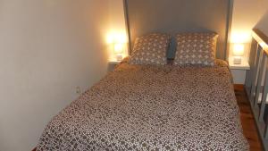 a bed in a small room with two lamps at Studio chez Nathalie & Eric in Mérignac