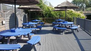 um grupo de mesas azuis e guarda-chuvas num deque em The Riverside em Spalding