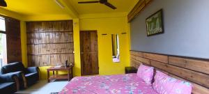 a bedroom with a bed and a chair and a window at West corner homestay in Shillong +12 photos