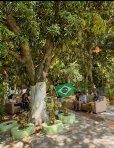 a group of people sitting under a tree at Paraguay Hostel Maison Belle in Asunción