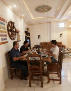 a group of men sitting at a table at Paraguay Hostel Maison Belle in Asunción