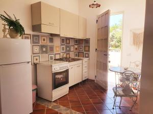 a kitchen with a stove and a refrigerator and a table at Villa Migliore in Lampedusa