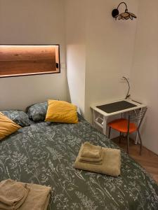 a bedroom with a bed with a desk and a desk at Location de Chambre SDB Cuisines in Charleroi