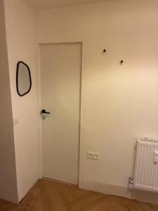 a white room with a door and a mirror at Location de Chambre SDB Cuisines in Charleroi