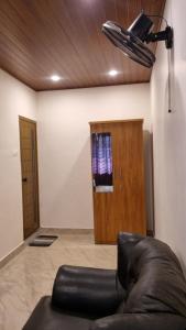 a room with a leather chair and a wooden door at Hotel Arena in Mahe