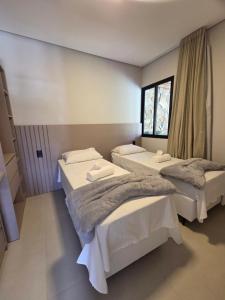 a bedroom with two beds and a window at Casa Luar de Pitinga in Arraial d'Ajuda