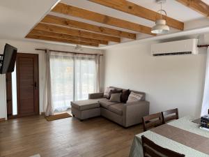 a living room with a couch and a tv at Casa Entre Cerros Panimávida in Colbún
