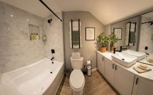 a bathroom with a tub and a toilet and a sink at Sleek Modern Villa - Centrally Located in Wilmington
