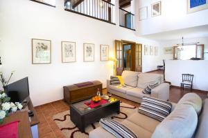 a living room with a couch and a tv at Villa Maina by Villa Plus in El Port