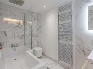 a white bathroom with a tub and a toilet at 3 Bed in Harrogate oc-86490 in Harrogate