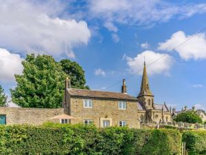 an old brick building with a church in the background at 3 Bed in Ripon oc-83728 in Healey