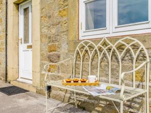 a white bench with a tray of fruit on it next to a building at 3 Bed in Ripon oc-83728 in Healey