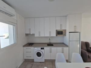 a kitchen with white cabinets and a washer and dryer at AR El ENCÍN TR-CC-00592 in Valdencin