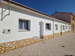 a white building with windows and a stone wall at AR El ENCÍN TR-CC-00592 in Valdencin