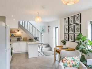 a kitchen and living room with a table and a staircase at The Kiln in Bolnhurst