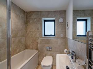 a bathroom with a tub and a toilet and a sink at 2 Bed in Bideford oc-91748 in Northam +7 photos