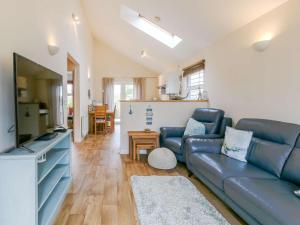 a living room with a blue couch and a kitchen at 2 Bed in Cowes oc-73374 in Gurnard