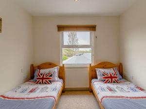 two beds in a room with a window at 2 Bed in Cowes oc-73374 in Gurnard