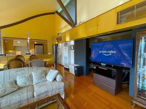 a living room with a couch and a flat screen tv at 熱海ブレスアネックス in Atami