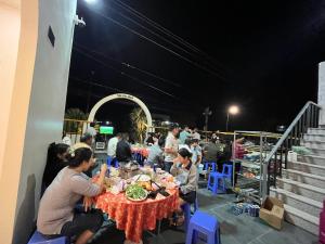 a group of people sitting at a table with food at LANBA Homestay in Phan Rang–Tháp Chàm