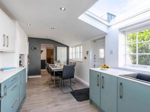 a kitchen with blue cabinets and a dining table at 4 Bed in Bideford oc-incot in Instow +22 photos