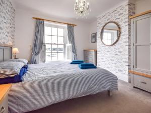 a bedroom with a large bed and a mirror at 4 Bed in Bideford oc-incot in Instow