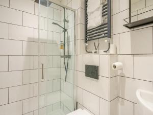 a white tiled bathroom with a shower and a sink at 4 Bed in Harrogate oc-73424 in Harrogate +10 photos