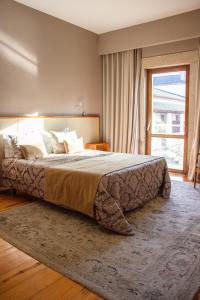 a bedroom with a large bed and a large window at Hotel Rural Casa de Samaioes in Chaves +132 photos