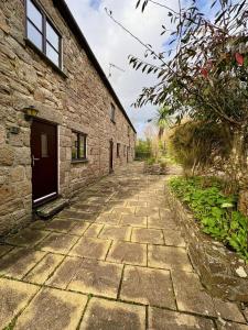 a stone house with a stone path next to a building at Saddle Cottage in Penzance