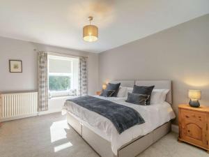 a bedroom with a large bed and a window at 4 Bed in Hexham oc-87458 in Catton