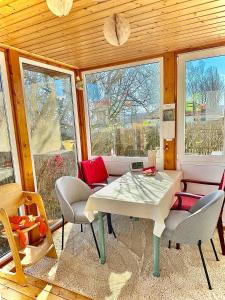 a dining room with a table and chairs and windows at Ferienwohnung Juttchen in Roßleben