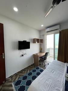 a bedroom with a bed and a desk and a television at Azure by Grehstay in Noida