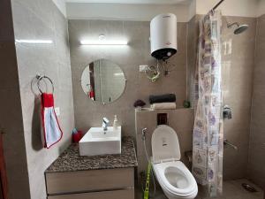 a small bathroom with a toilet and a sink at Azure by Grehstay in Noida +19 photos
