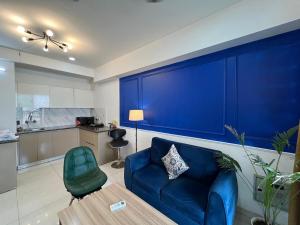 a living room with a blue couch and a table at Azure by Grehstay in Noida