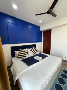 a bedroom with a large bed with blue walls at Azure by Grehstay in Noida