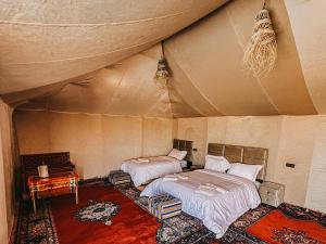 a bedroom with two beds in a tent at Big Dipper Luxury Camp in Merzouga