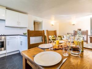 a kitchen with a table with plates and glasses on it at 3 Bed in Braunton oc-87107 in Croyde +9 photos