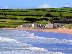 a beach with houses and people in the water at 3 Bed in Braunton oc-87107 in Croyde