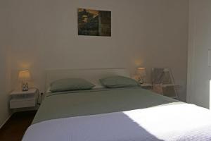 a bedroom with a bed with two tables and two lamps at Apartment Terrarossa 2 in Fažana