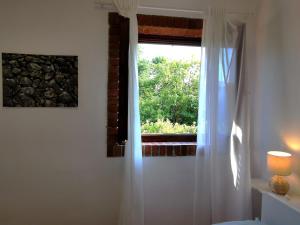 a window with a white curtain in a room at Apartment Terrarossa 2 in Fažana