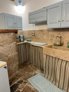 an unfinished kitchen with white cabinets and a sink at La mia casetta country chic in Ozieri +25 photos
