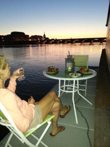 una mujer sentada en sillas en un barco con una mesa en Different Holidays, en Saumur