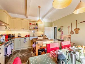 a kitchen with white cabinets and a table with pink chairs at 3 Bed in Leyburn oc-g0185 in Carlton