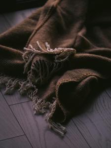 a brown blanket sitting on top of a wooden floor at Гойра in Dzembronya