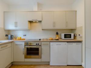 a kitchen with white appliances and white cabinets at 2 Bed in Alnwick oc-78956 in Embleton