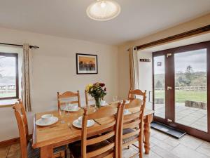 a dining room with a wooden table and chairs at 3 Bed in Bideford oc-05171 in Woolfardisworthy +13 photos