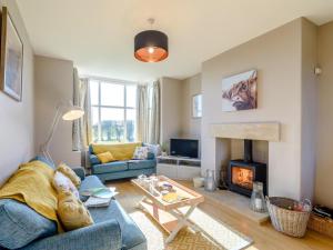 a living room with a blue couch and a fireplace at 3 Bed in York oc-79525 in Deighton