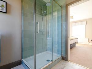 a glass shower in a bathroom with blue tiles at 3 Bed in York oc-79525 in Deighton +23 photos