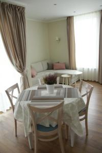 comedor con mesa, sillas y sofá en Full House Apartments en Druskininkai